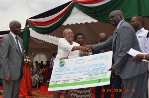 First Lady Margaret Kenyatta receives a chegue of Sh100,000 from Wote KCB Manager Lawrence Musyoka during the launch of Beyond Zero Campaign mobile clinic in Makueni as Governor Kivutha Kibwana looks on. Photo:Mary Lole 